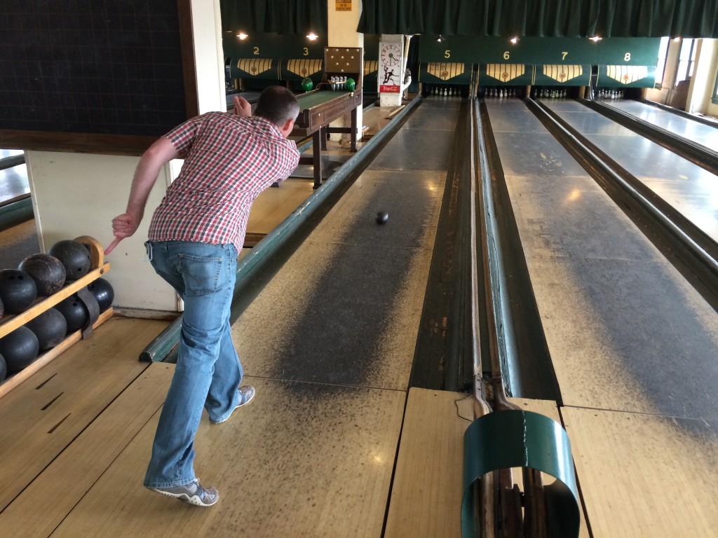 A man bowling in a strategic branding services-themed bowling alley.