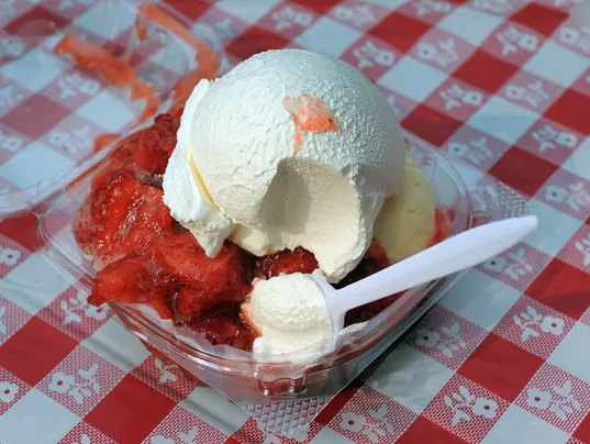 A bowl of ice cream and strawberries with integrated marketing solutions.